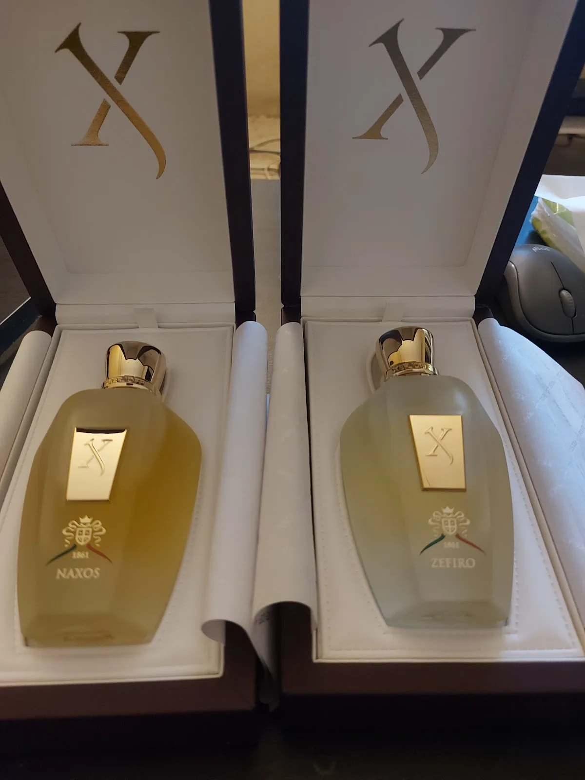 Two boxed niche fragrances presented in cream gift cases