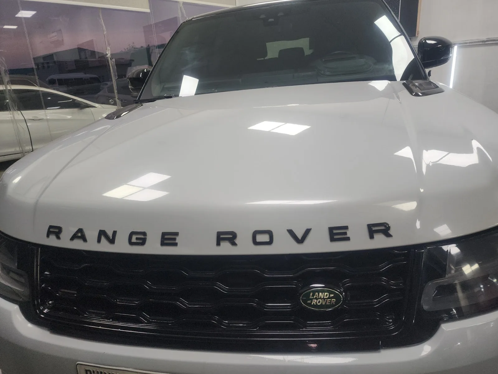 A white luxury SUV parked inside the indoor service area