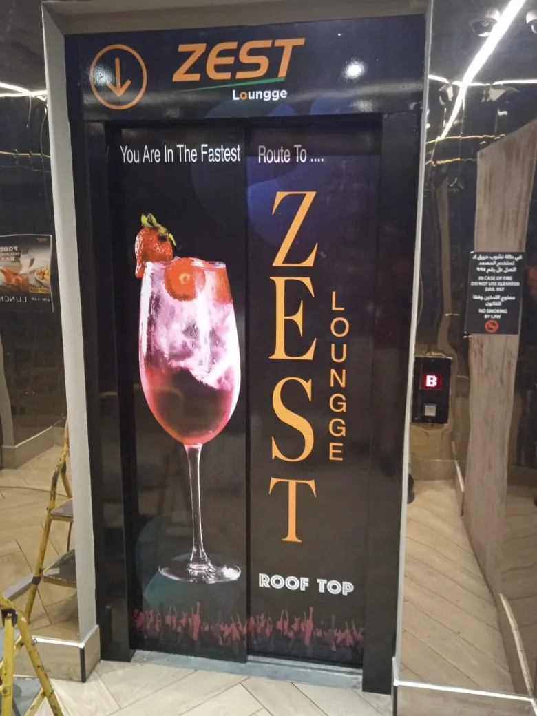 Printed lift door wrap branding a rooftop lounge
