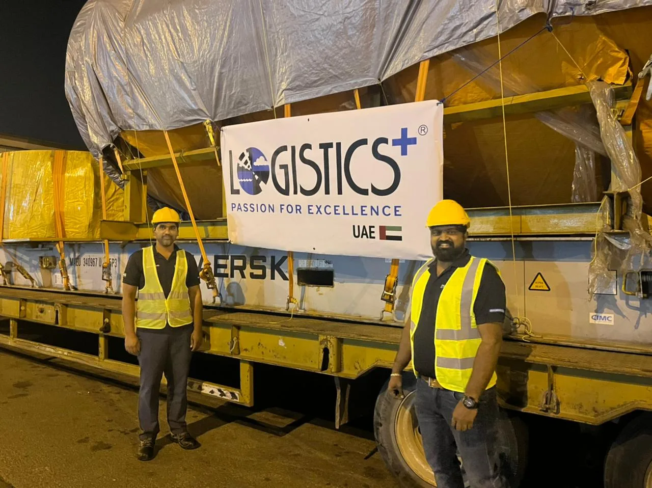 Team installing a large printed banner on site at night