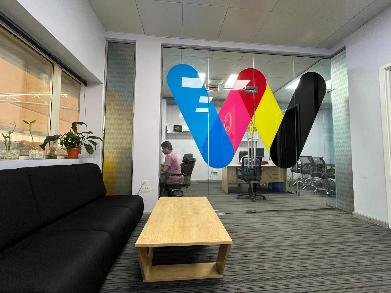 Al Wasl Printing Press studio with the brand mark applied in CMYK to glass partitions