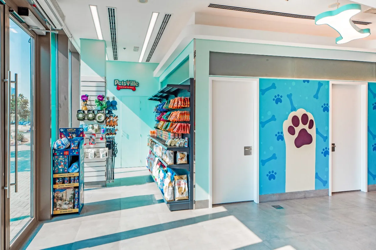The bright Petsville store entrance with paw-print wall art and pet products