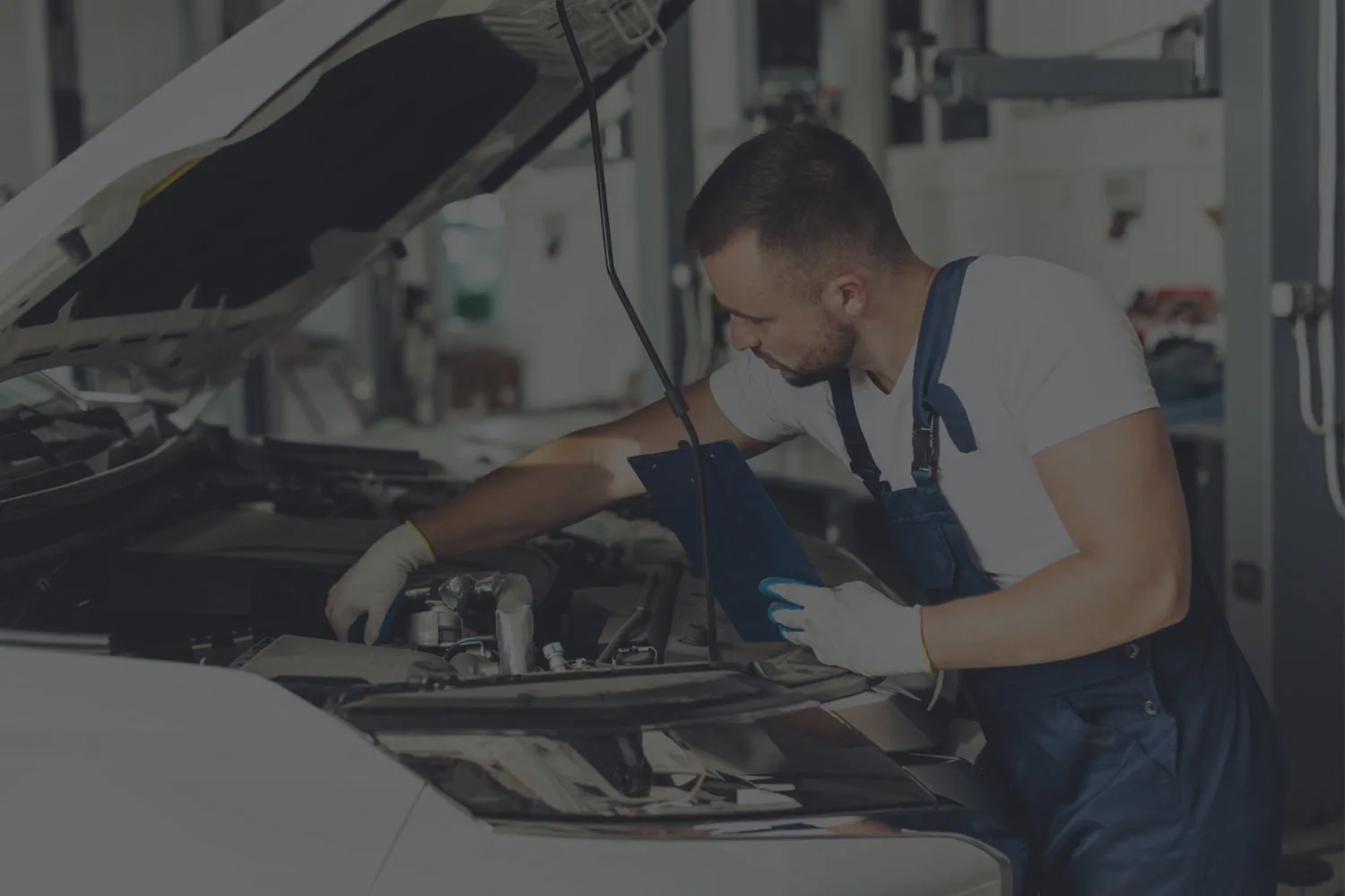 AutoMedic mechanic inspecting a car engine with a clipboard