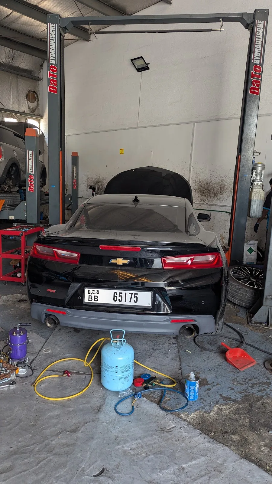 Car in the workshop with air-conditioning service equipment