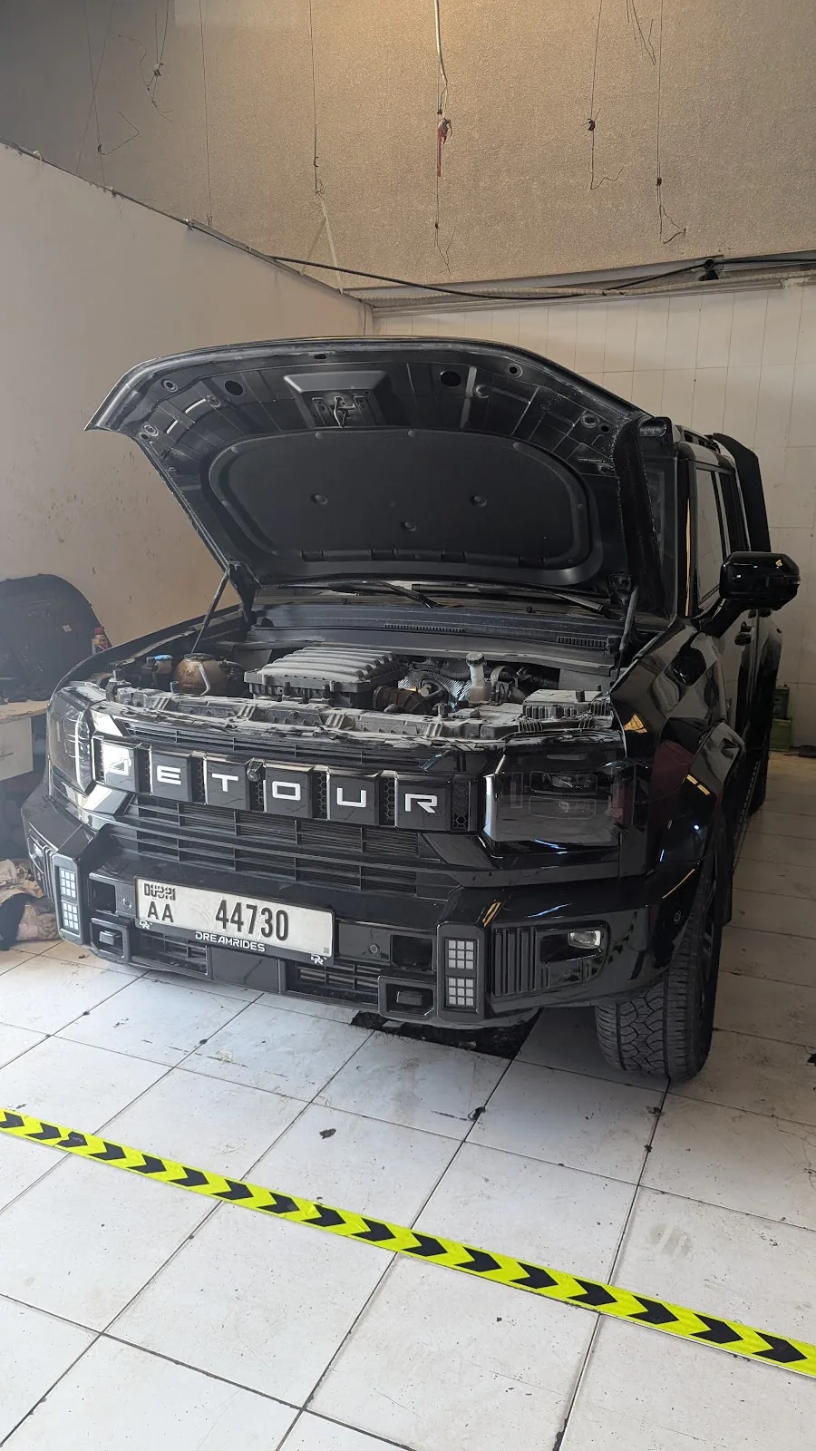 Black SUV with its hood open during inspection