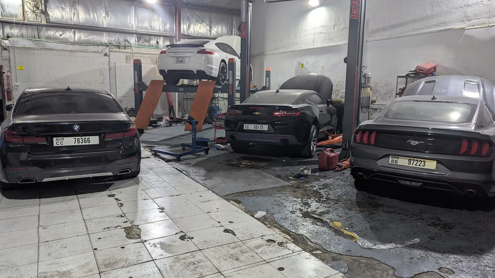 BMW, Chevrolet Camaro and Ford Mustang on lifts inside the AutoMedic workshop