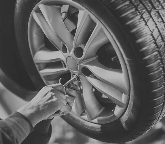 Mechanic working on a car wheel and suspension