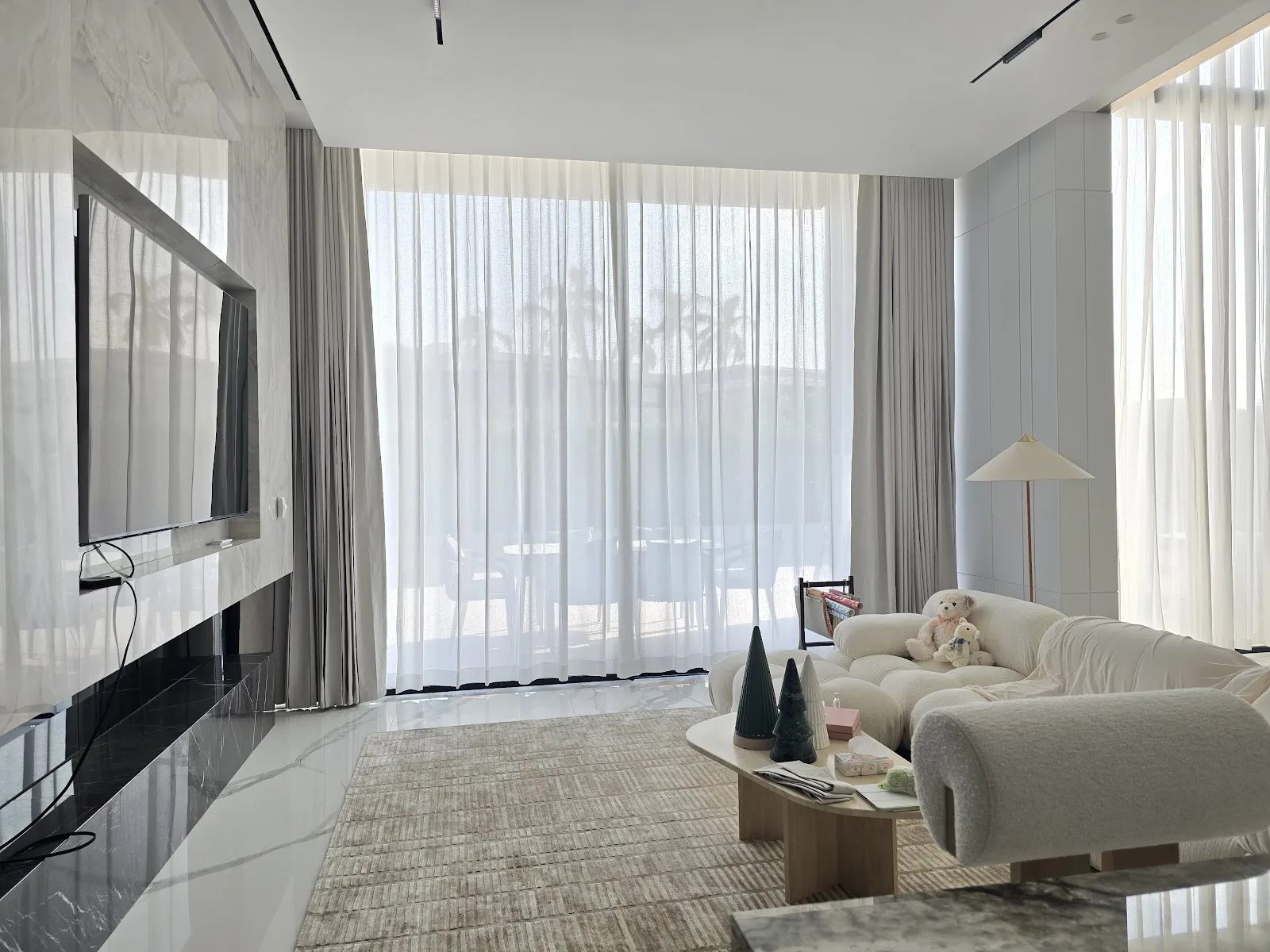 Floor-to-ceiling sheer curtains in a bright Dubai living room installed by Decent House Curtains
