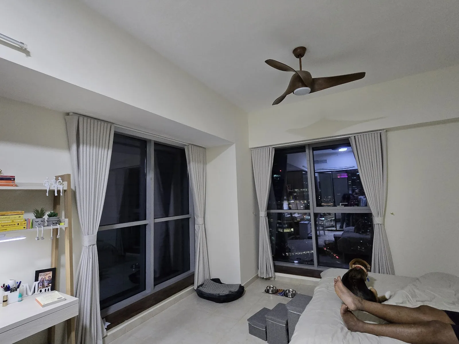 Bedroom with grey curtains over sliding glass doors at night