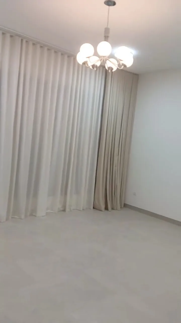 Floor-length cream curtains in a room with a chandelier