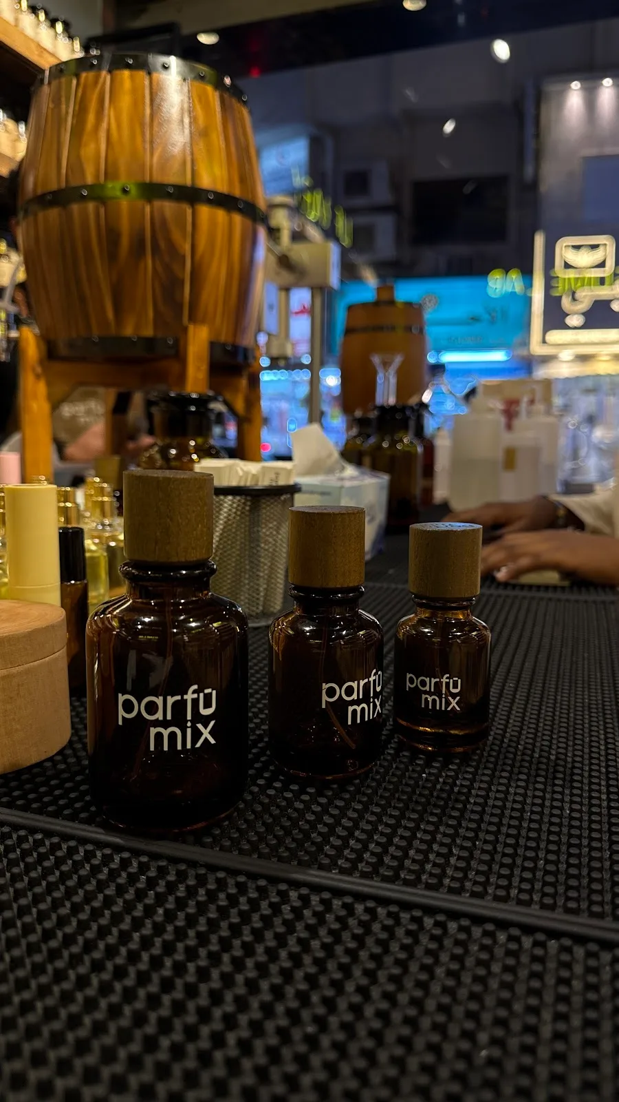 Three amber Parfumix bottles lined up on the counter mat