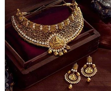 Antique-finish gold temple choker with a goddess motif pendant and matching jhumka earrings