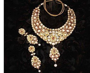 Elaborate polki and kundan bridal necklace set with pearl drops on a dark backdrop