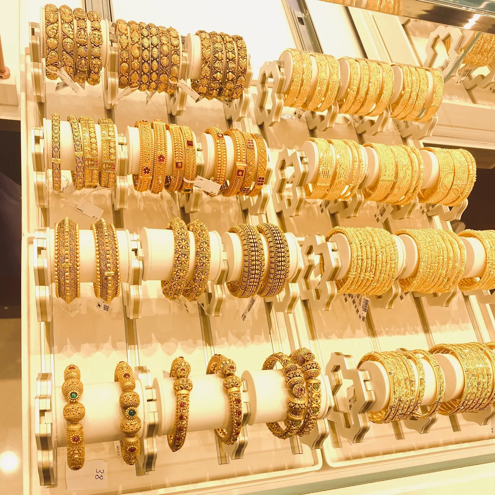 Display rows of intricately patterned 22K gold bangles
