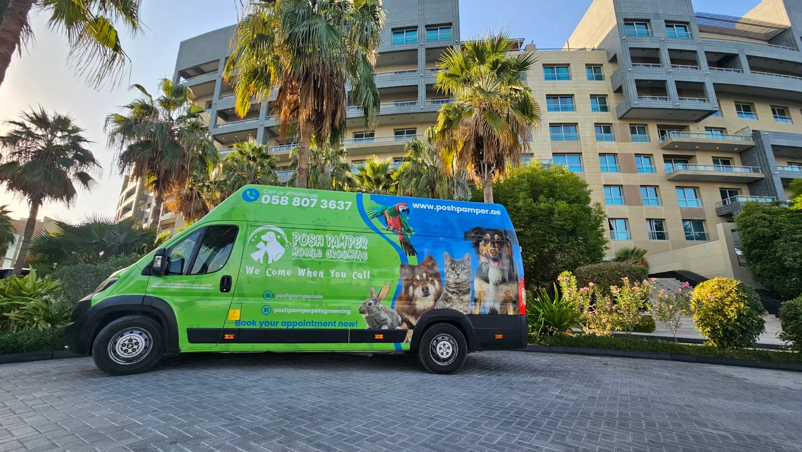 Posh Pamper green grooming van parked by palm trees