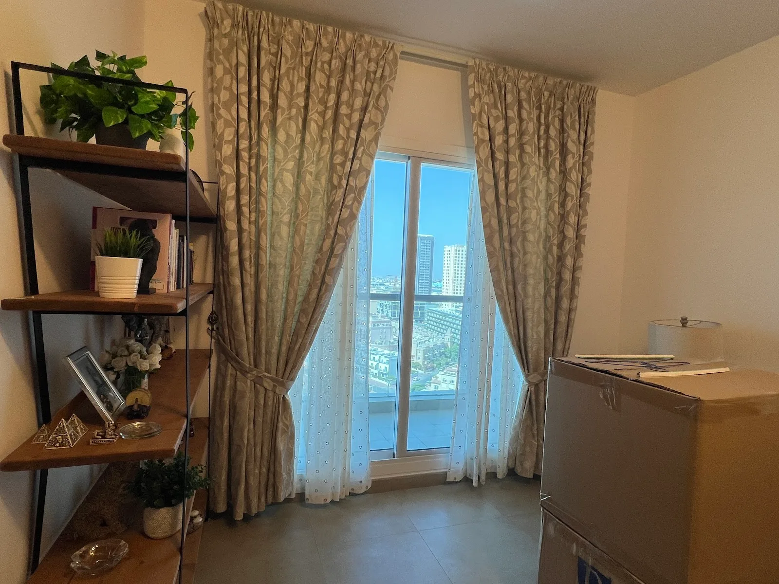 Patterned leaf curtains and sheers framing a city view