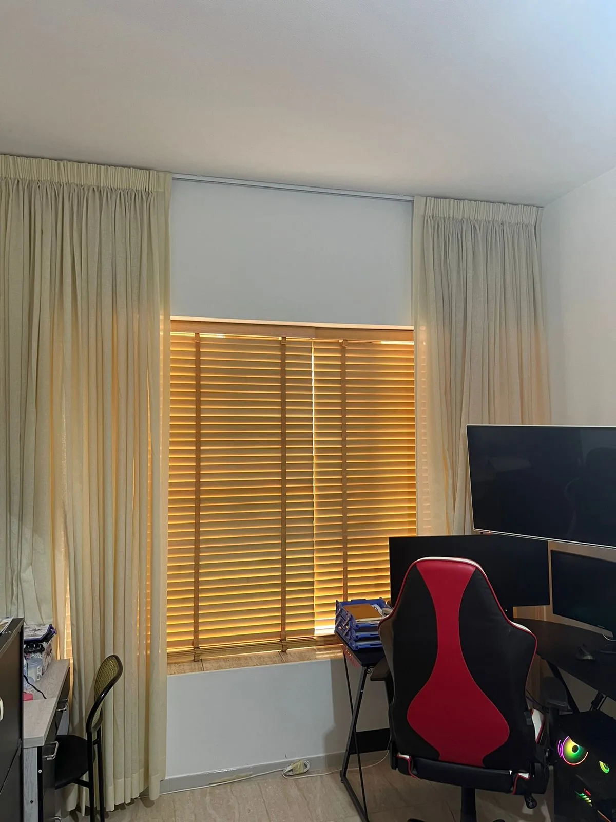 Cream sheers paired with wooden venetian blinds in a study