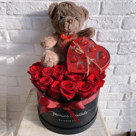 Red roses in a black box with a teddy bear and heart chocolate box