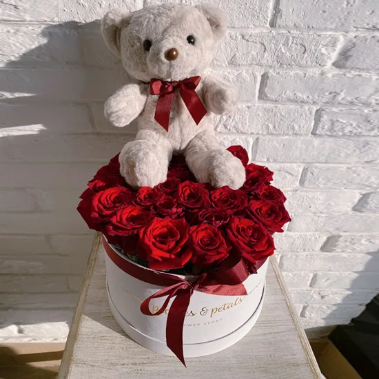 Red roses in a white box topped with a white teddy bear