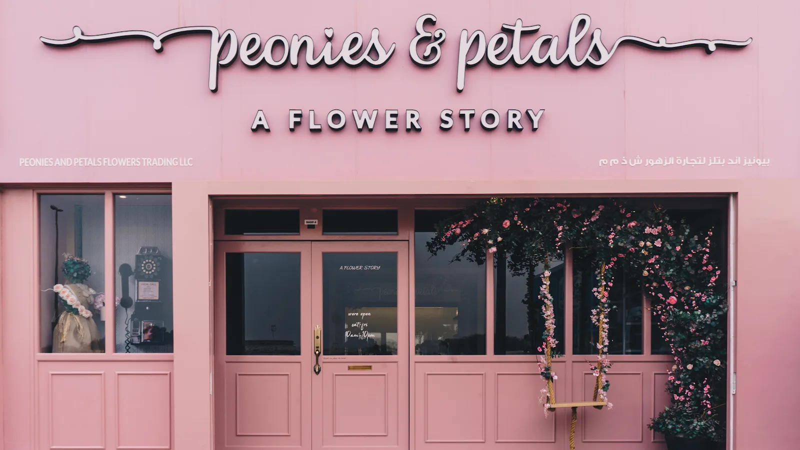 The blush-pink Peonies & petals storefront on Hessa Street, with floral arch and swing by the door