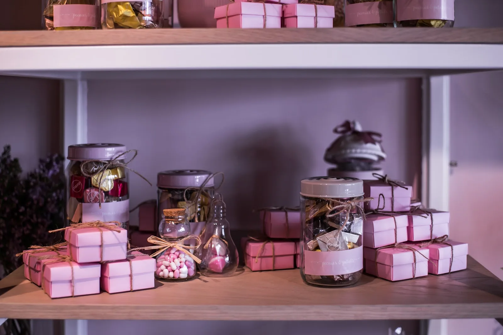 Shelves of pink gift boxes and treat jars inside the studio