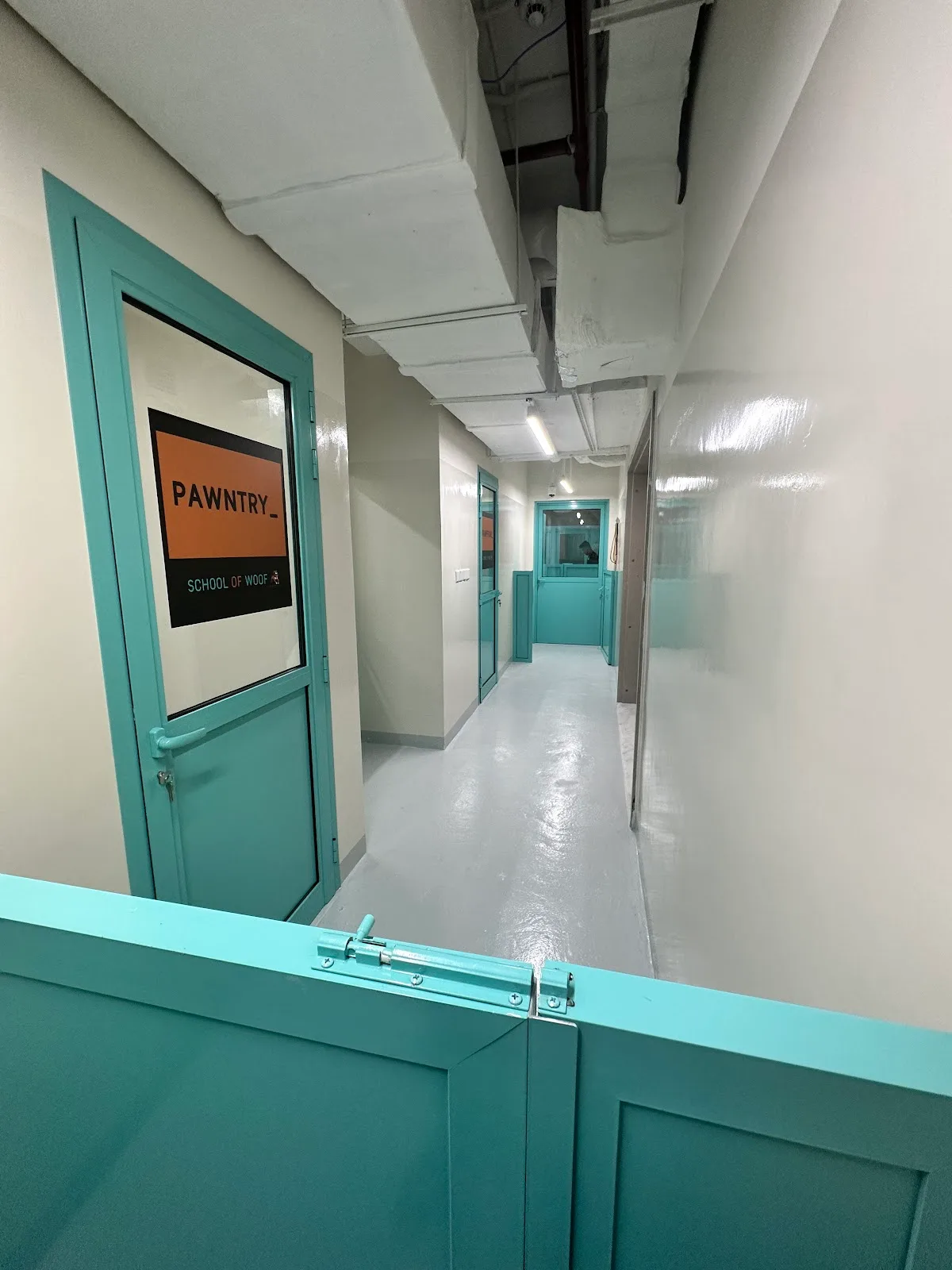 The Pawntry corridor with teal doors inside the facility