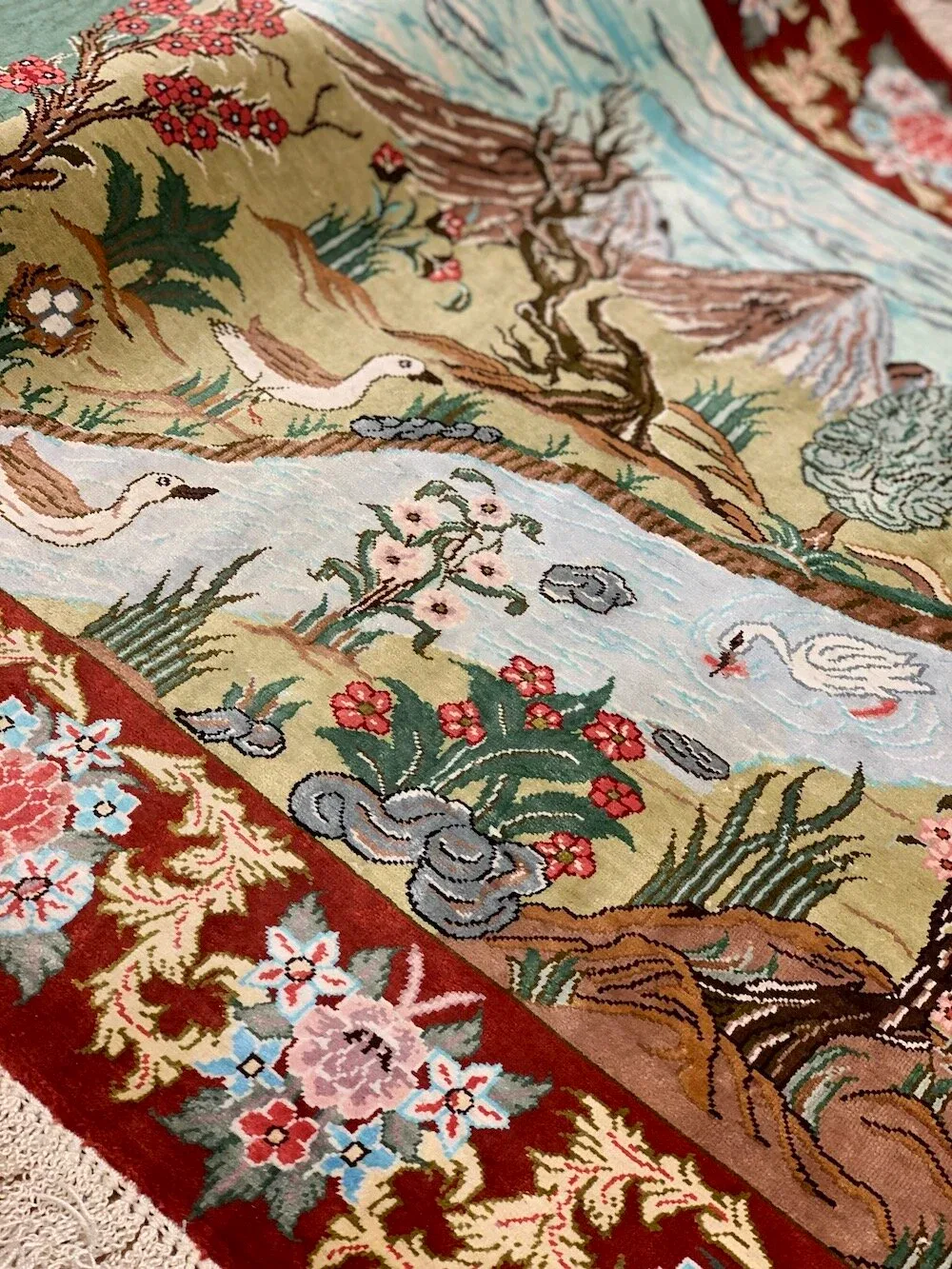 Pictorial silk carpet detail with cranes among flowers