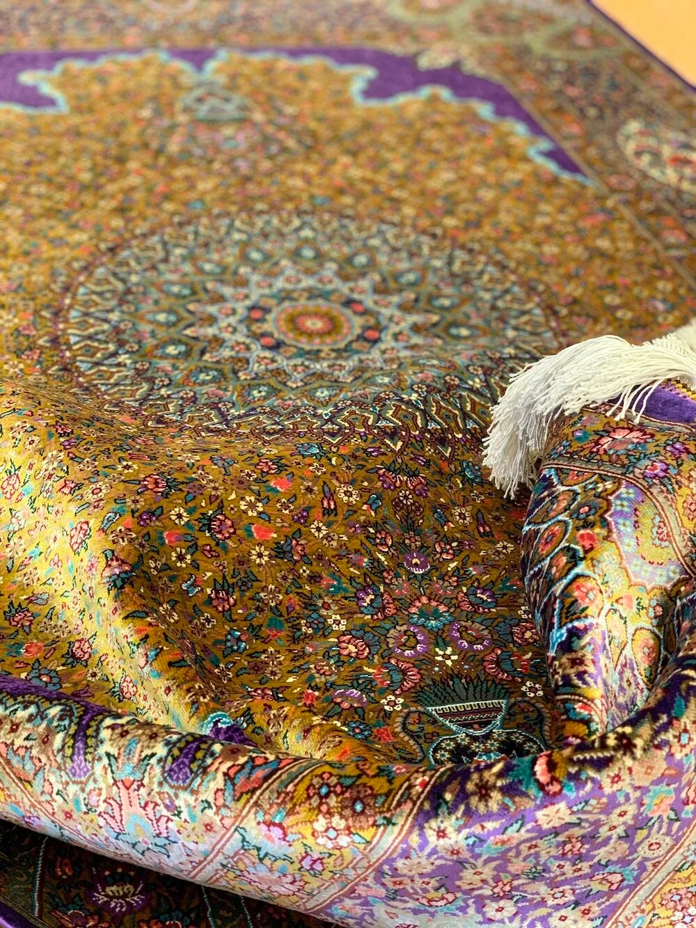 Purple and gold silk carpet with a radiant central medallion