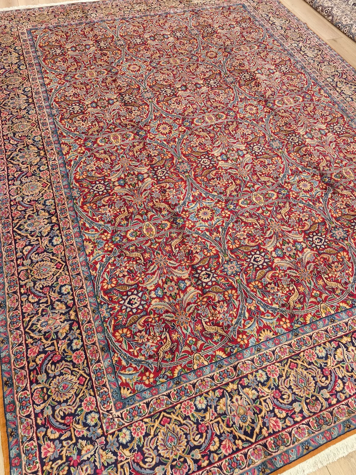 Antique-style red Persian carpet with a dense floral field