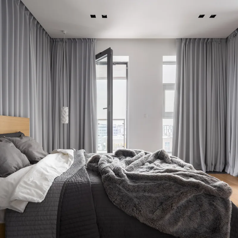 Full-height grey drapes in a bedroom