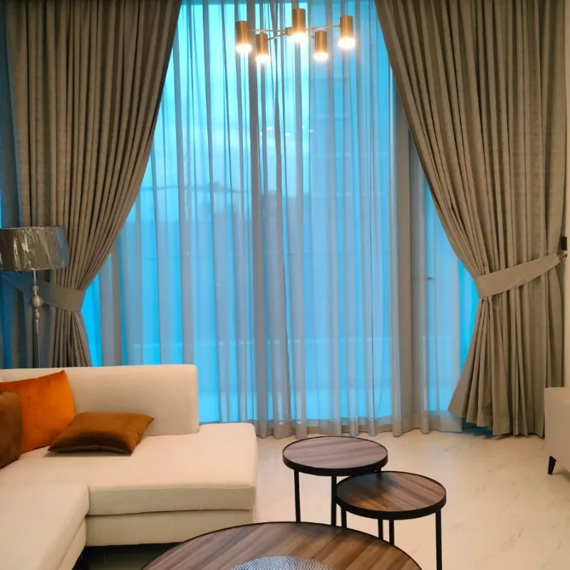 Layered taupe curtains over sheers in a living room