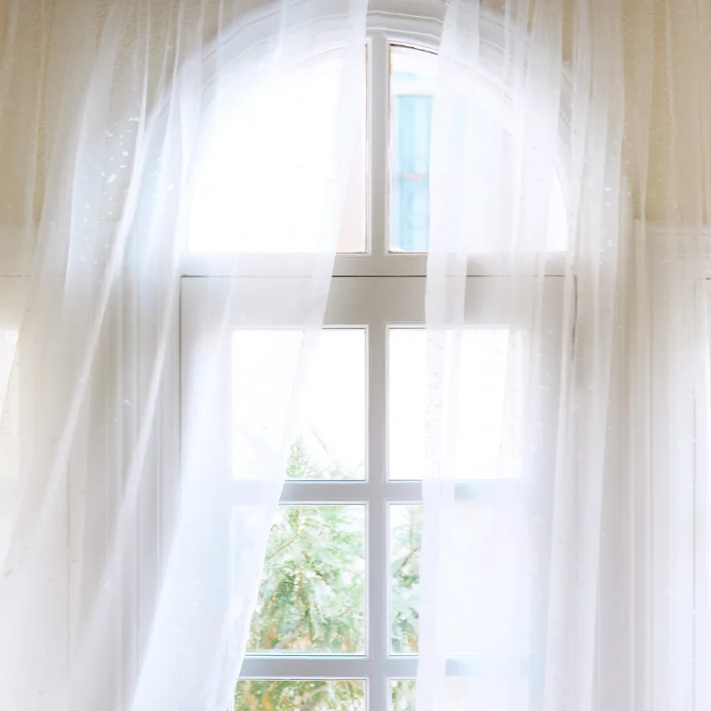 White voile sheers at a bright window
