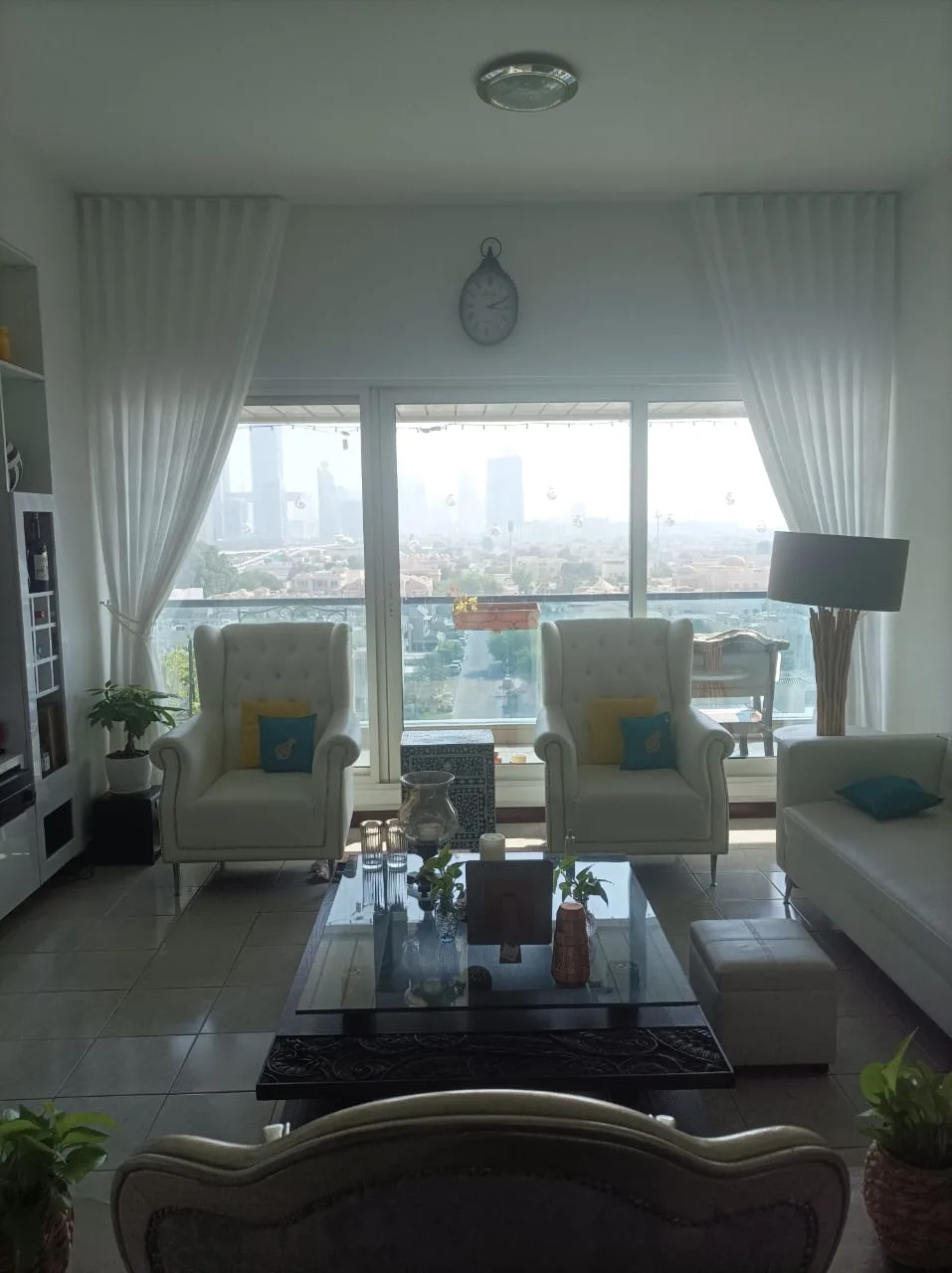 Wingback armchairs and sheers with a city view