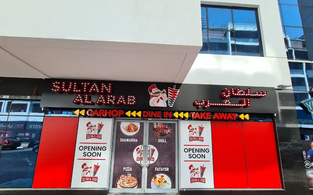 The Sultan Al Arab shopfront in Al Barsha, Dubai — illuminated red sign over the Nada Building, Barsha 1