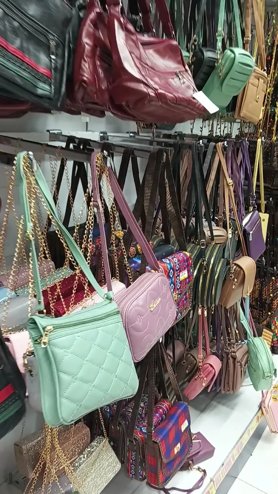 Wall of handbags, crossbody bags and purses on display at Gifts Village