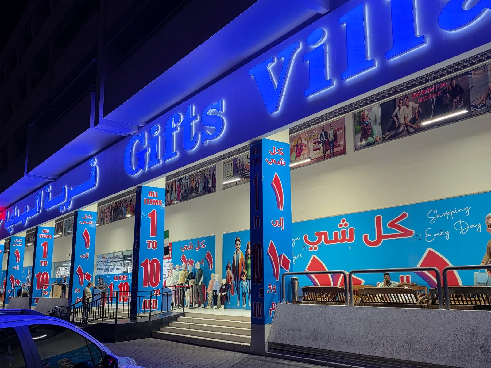 Gifts Village storefront on Salah Al Din Street, Deira, lit up at night with bright blue signage and 1 to 10 AED banners