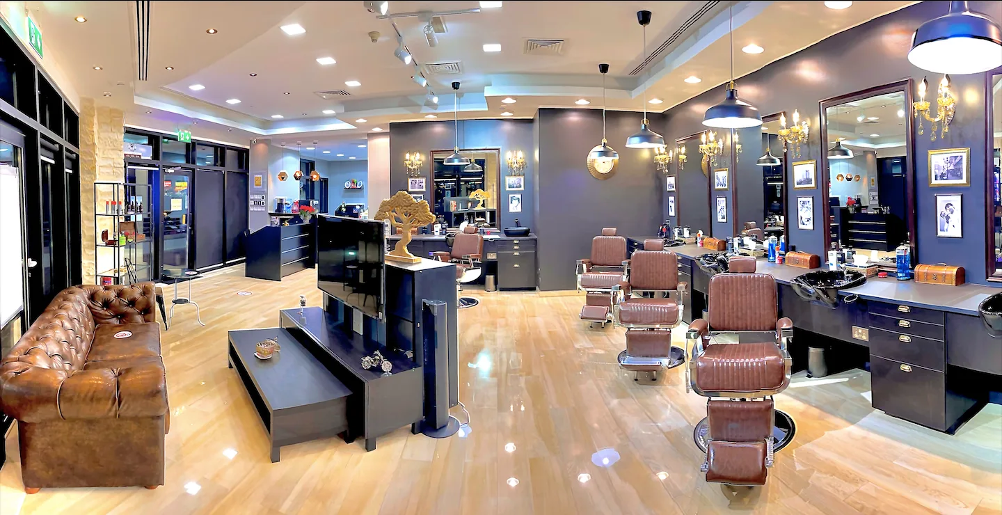 Wide view of the James Pro Barbers floor with leather barber chairs and chandeliers