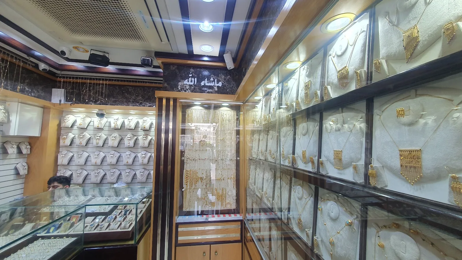 Interior of Red Rose Jewellery showing gold necklaces and a watch display case