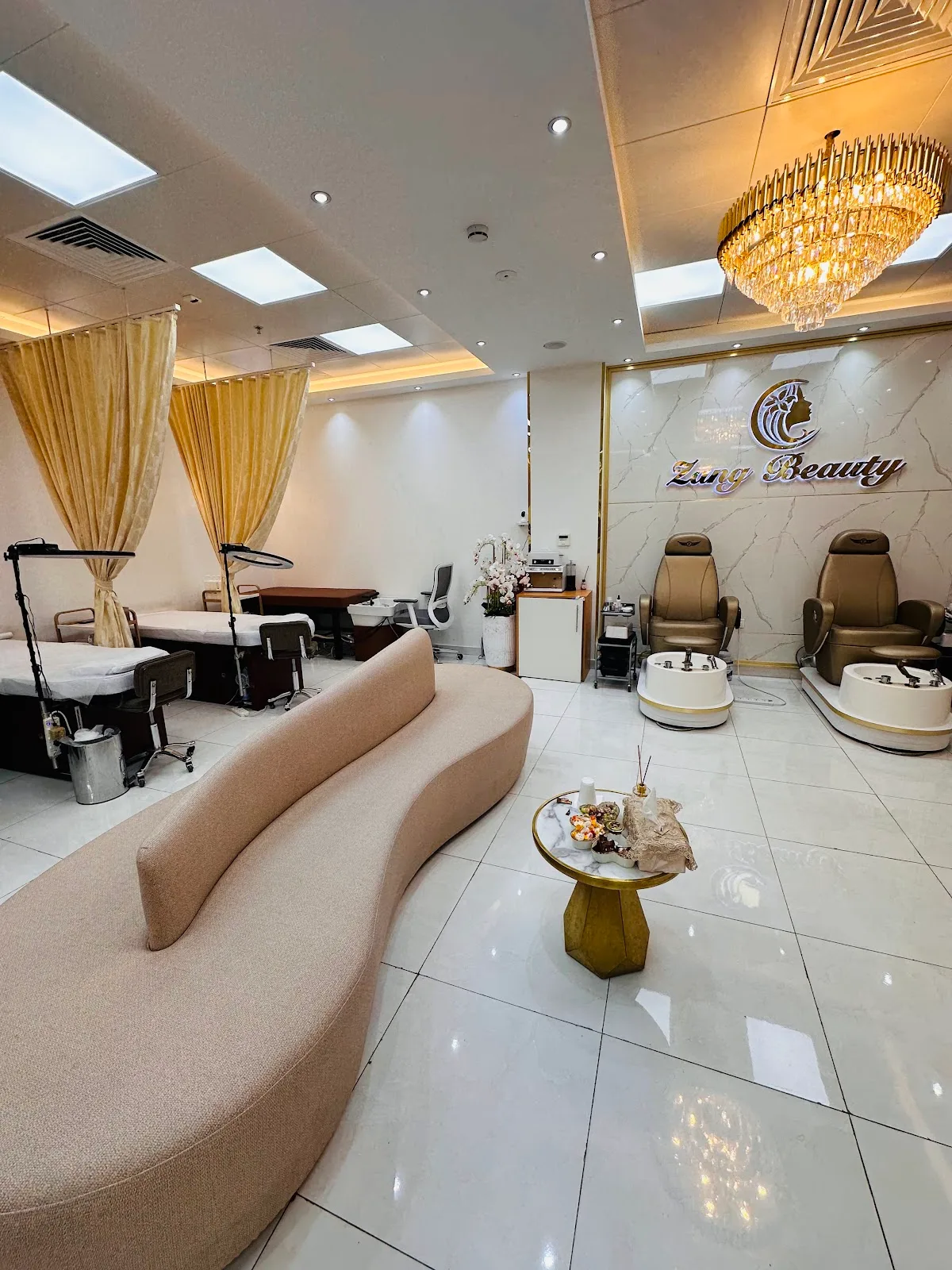 Zang Beauty salon lounge in Al Rigga with curved sofa, chandelier and gold marble brand wall