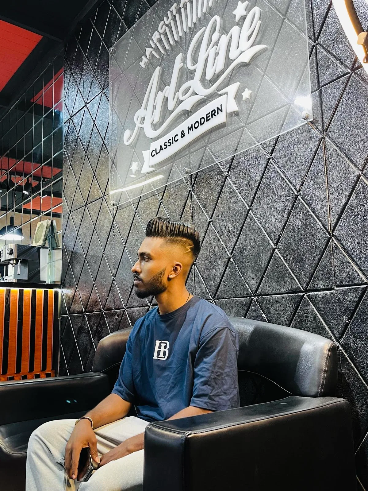 A client with a fresh pompadour fade haircut at ArtLine Gents Salon's signature mirror wall