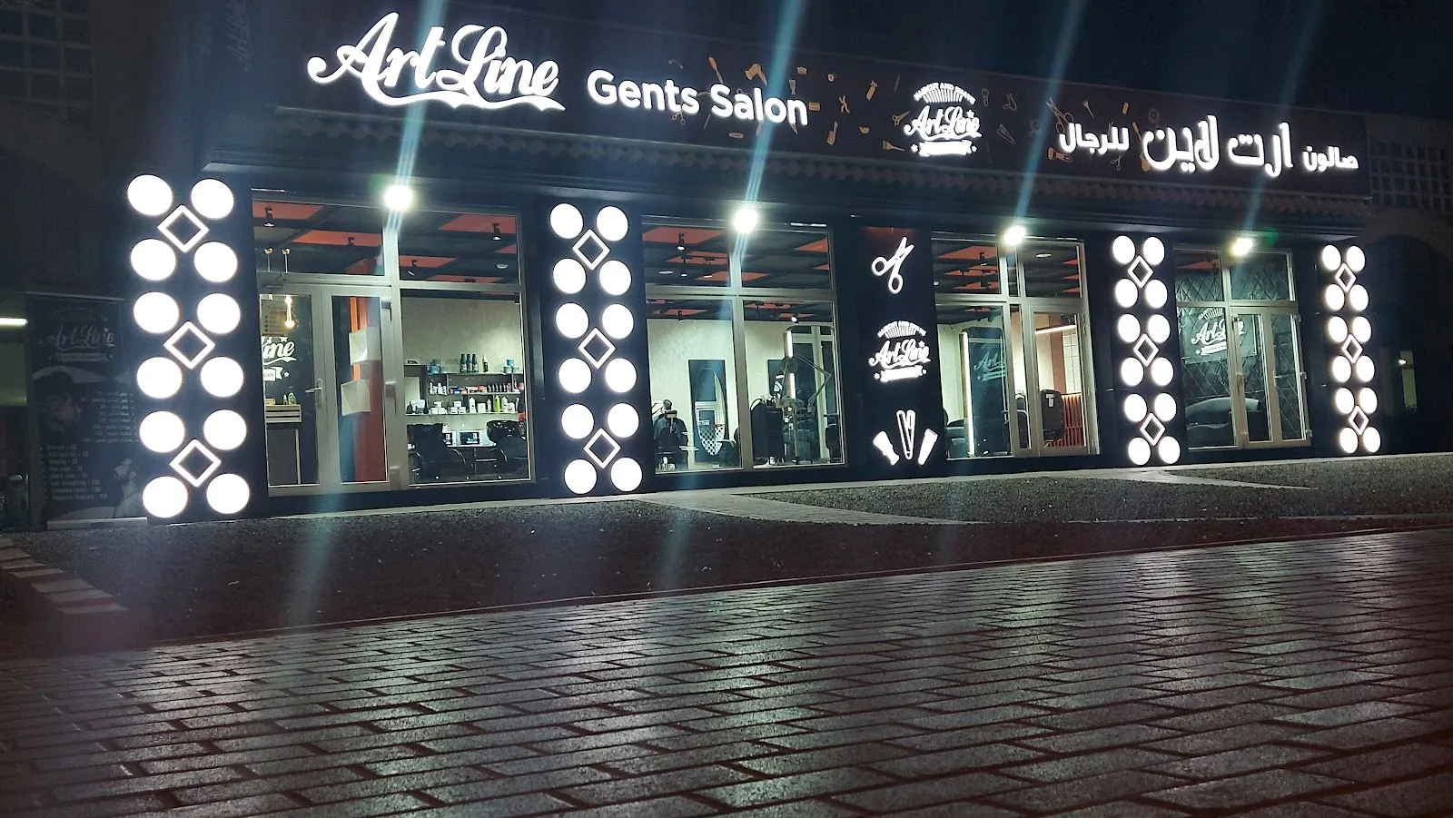 ArtLine Gents Salon illuminated shopfront at night in Dubai International City