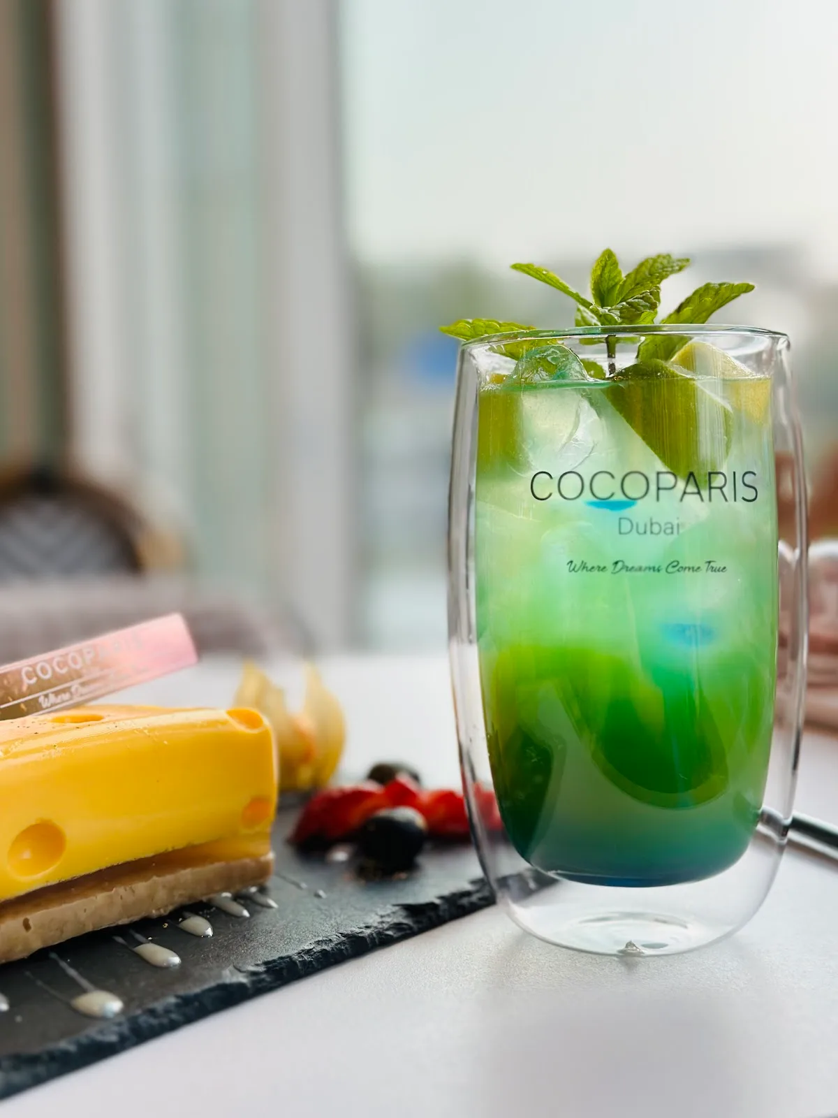 Branded COCOPARIS double-wall glass with a green cooler and mint