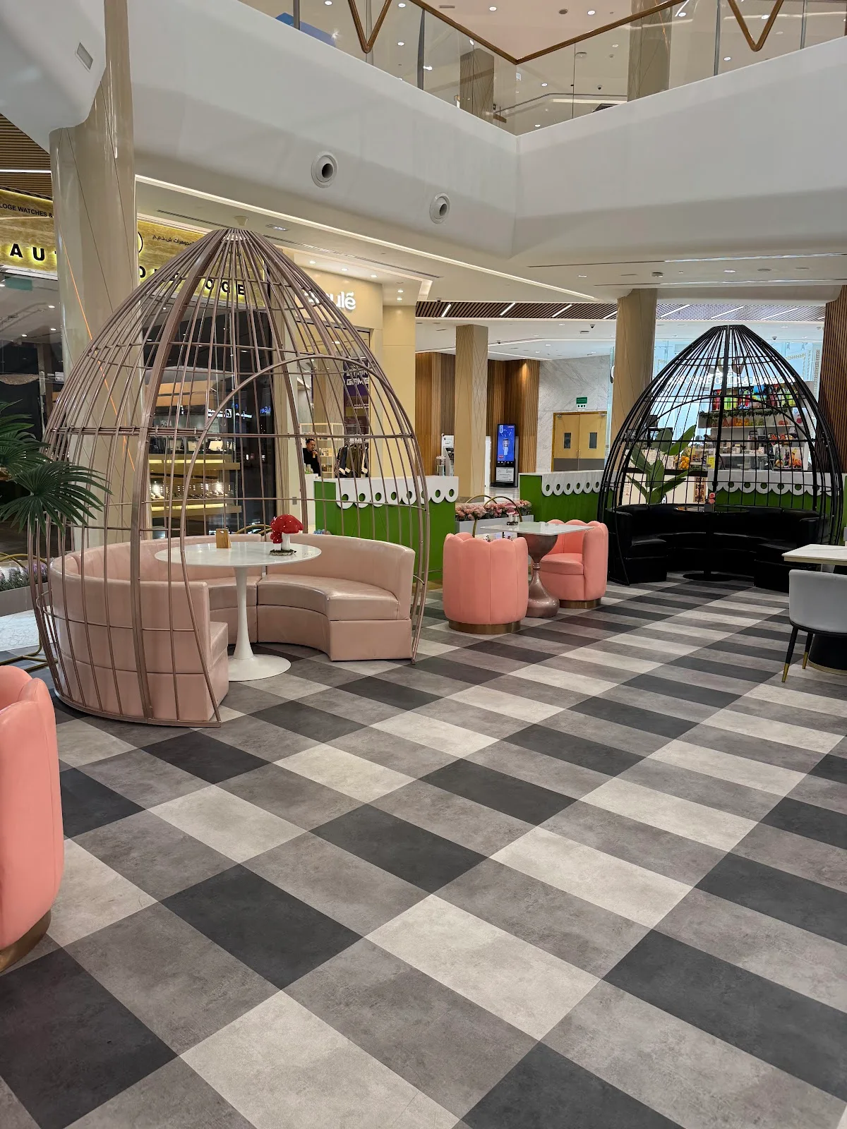 Birdcage pods and pink tulip chairs in the atrium