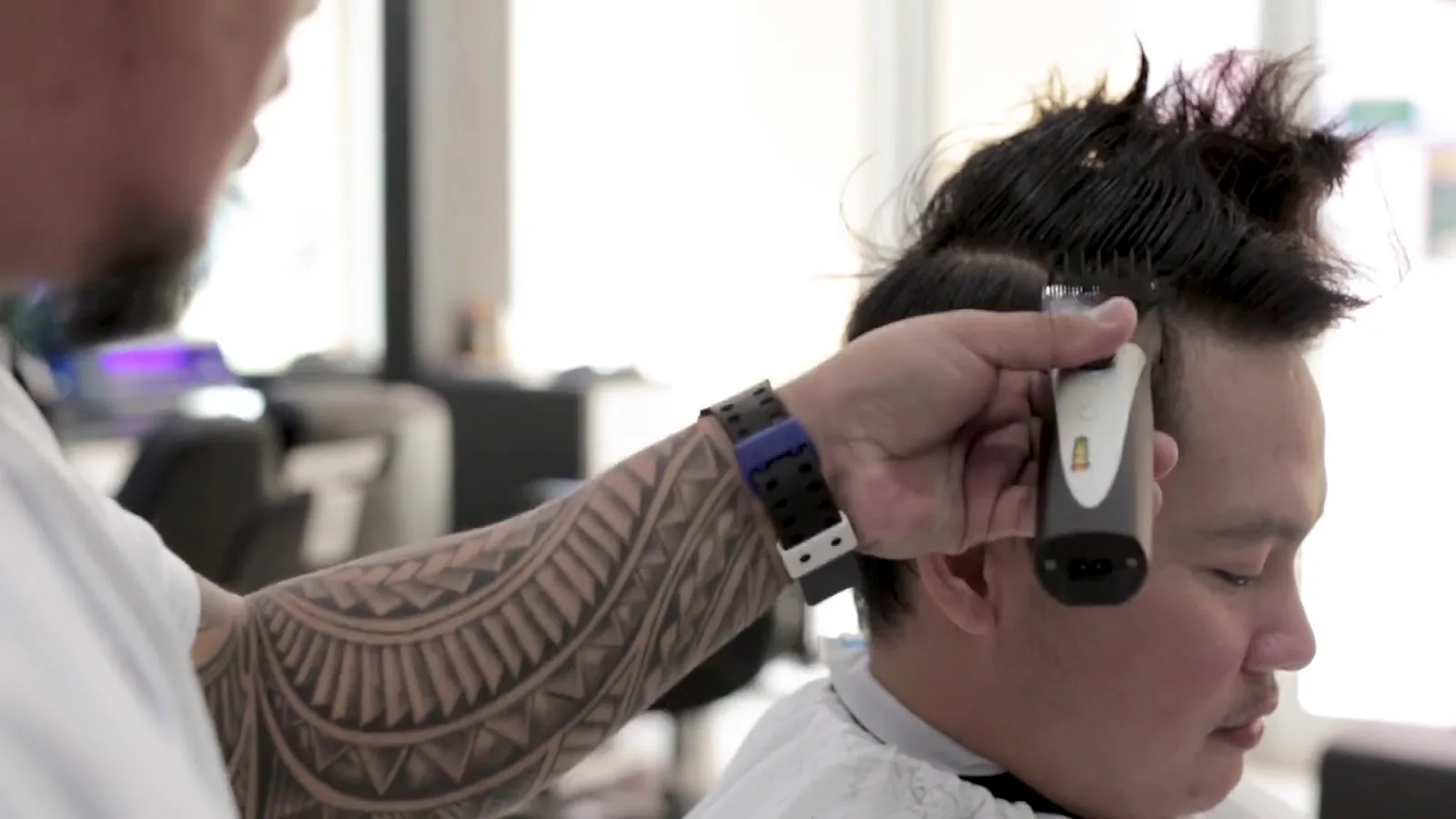 Barber giving a precise clipper cut to a client at Facelook