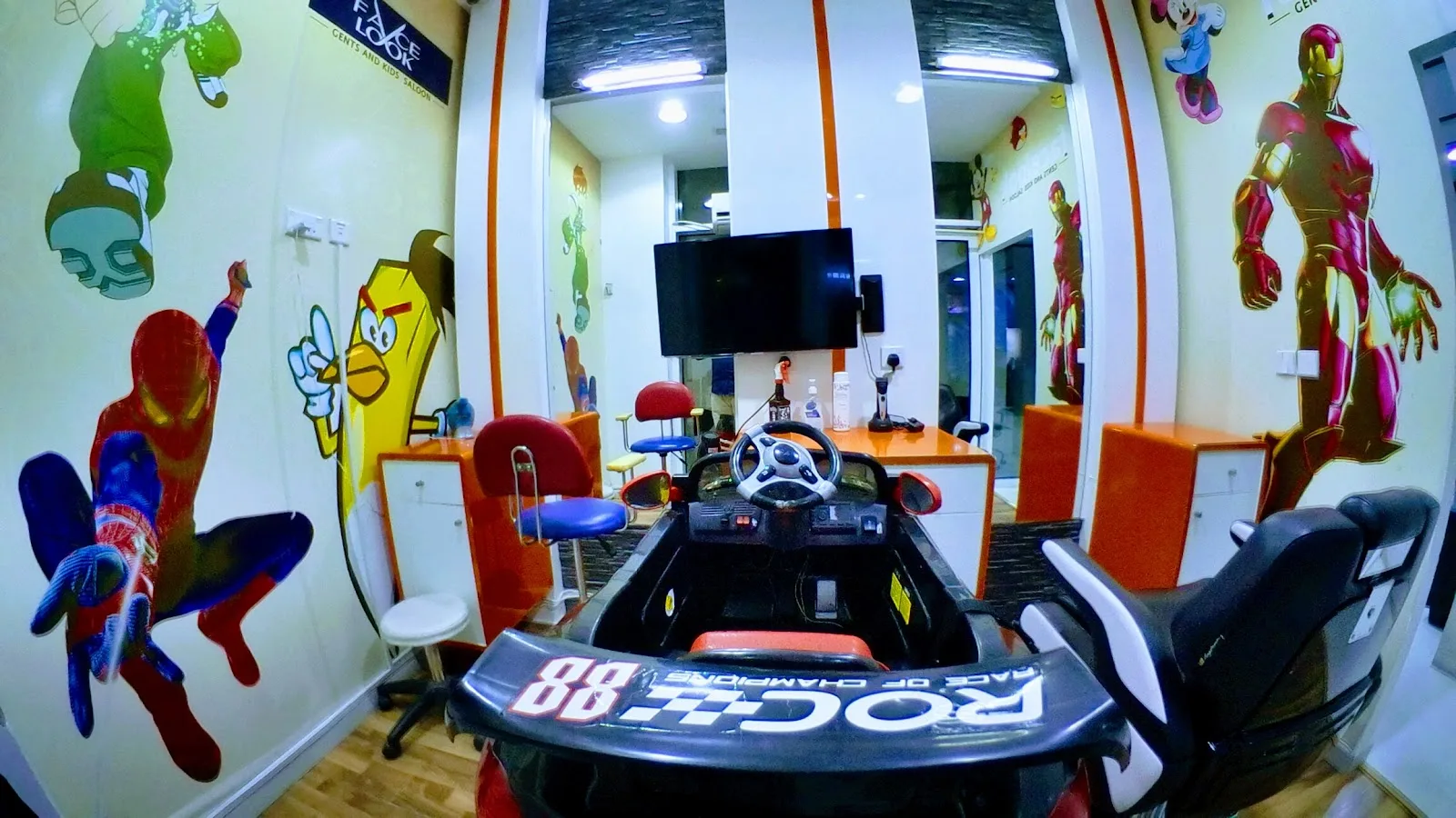 Kids haircut corner with character decals and a race-car styling chair