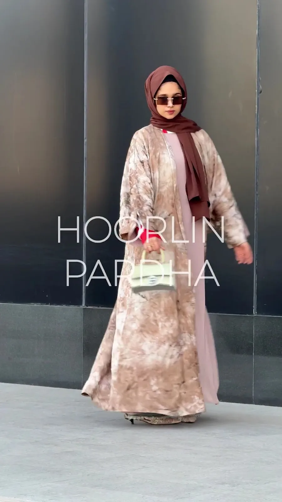 Model in a tan printed open abaya over a blush inner dress