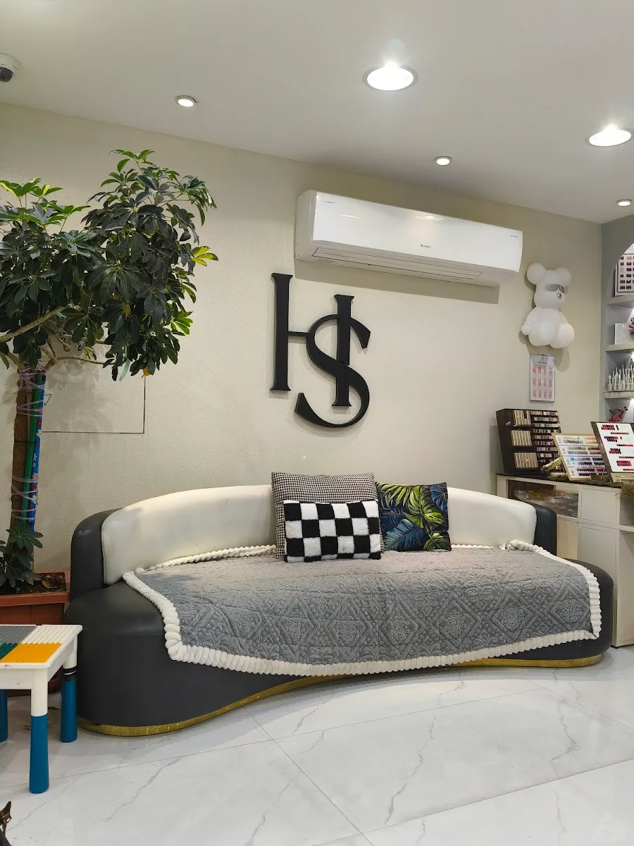 The relaxed lounge inside Hollywood Ladies Salon, Al Rigga branch, with the salon's monogram on the wall