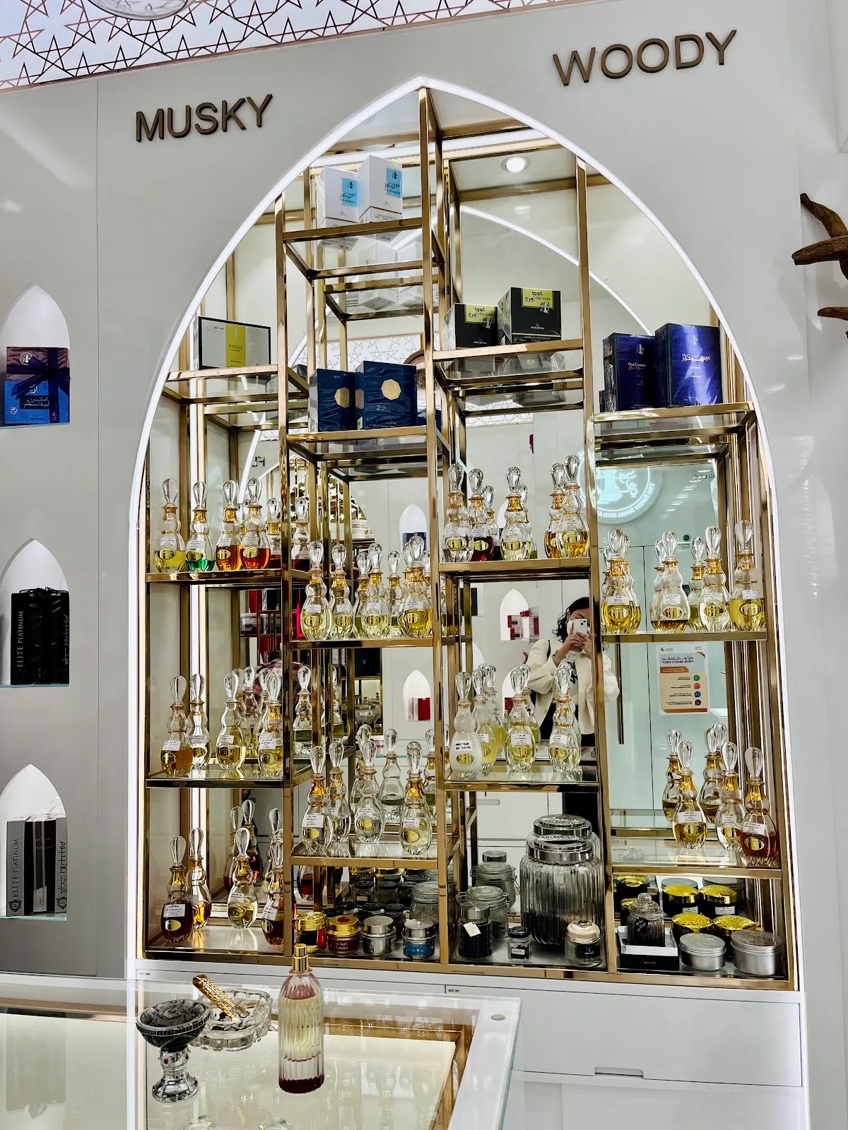 Gold arched display case of perfume bottles