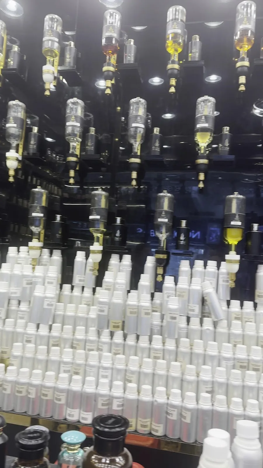 Wall of oud oil dispensers and decanters inside Oud Al Mashreq perfume bar