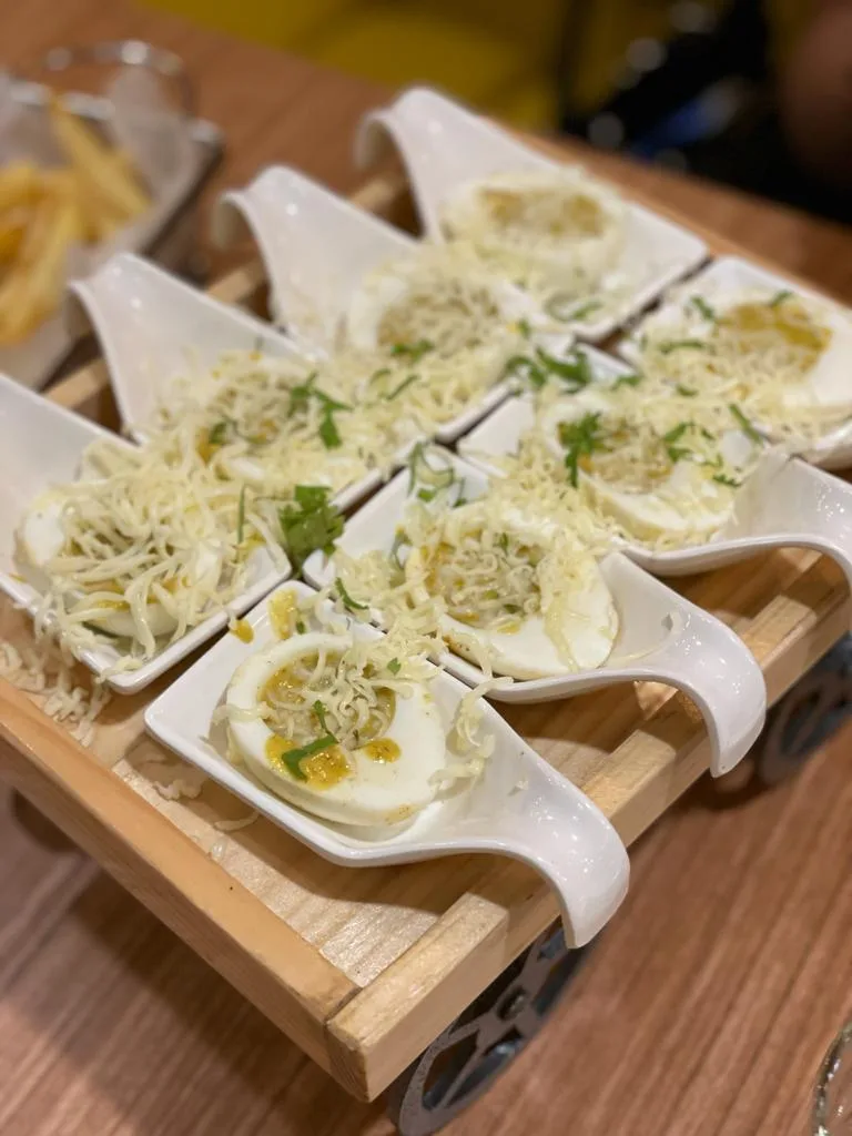 Eggiterian's signature cheese-and-herb topped egg platter served on a little wooden cart